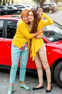 Happy young girl hugging his mom while holding car keys